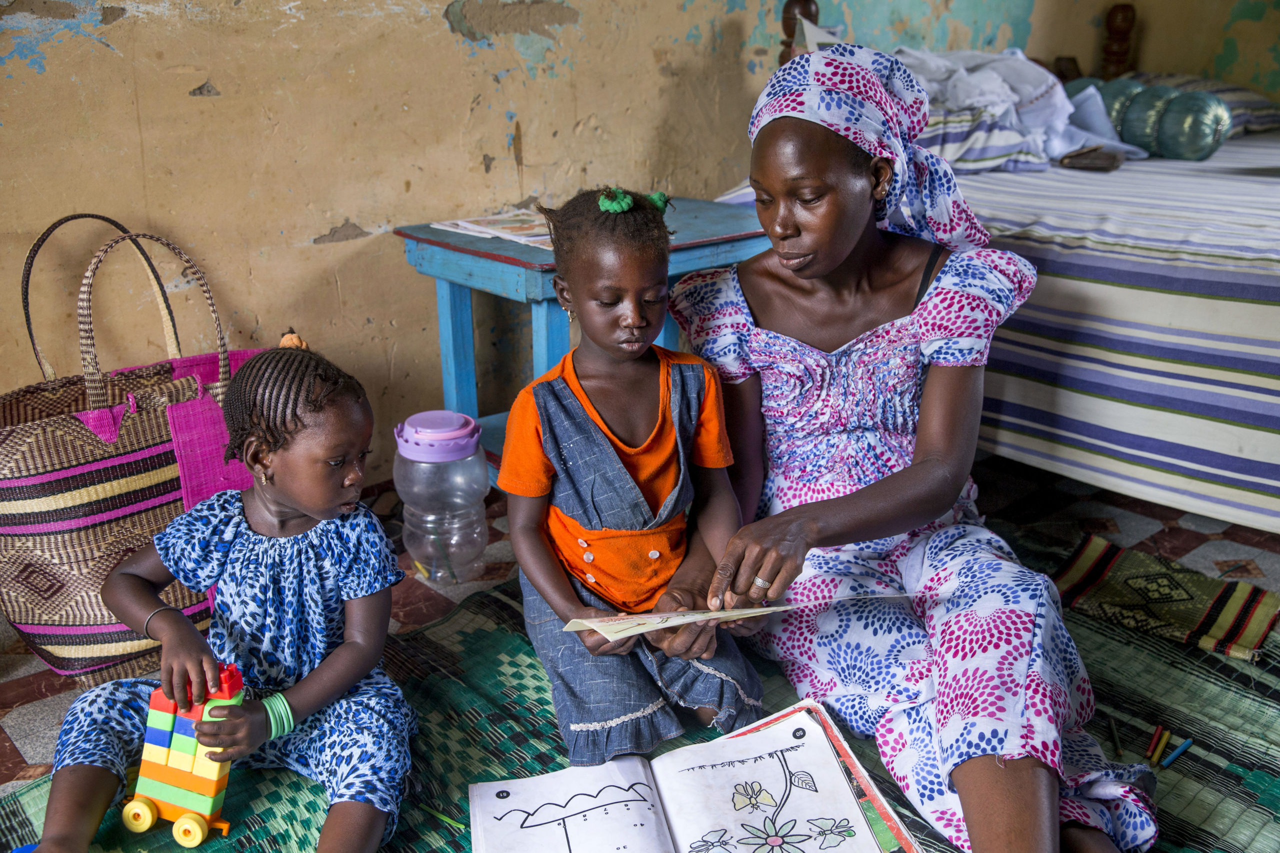 A mother interacting with her daughter, and using reading and coloring books